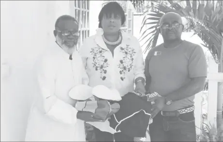  ??  ?? Waveney Benn, centre, athletic coach Leslie Black, right, and Monsignor Terrence Montrose of the Church of the Immaculate Conception display some of the equipment.