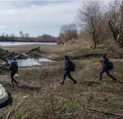  ?? Getty ?? Migranten proberen aan de Turks-Griekse grens in een opblaasbaa­r bootje de Evros over te steken. ©