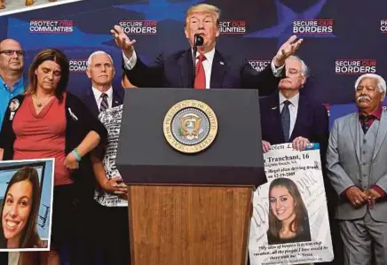  ?? REUTERS PIC ?? United States President Donald Trump with parents of victims killed by illegal immigrants, at the White House in Washington, D.C., on Friday.