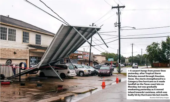  ?? Brandon Bell/Getty Images ?? A carport hangs from power lines yesterday, after Tropical Storm Nicholas moved through Houston, Texas. The storm strengthen­ed to a Category One hurricane as it made landfall on the Texas coast late on Monday, but was gradually weakening yesterday as it moved inland towards Louisiana, which was badly hit by Hurricane Ida last month.