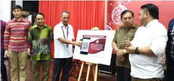  ??  ?? Penguang (centre) performs the symbolic launch of the QR Code for Bau District Council’s bulletin. With him on stage are (from right) Miro, Ranum, Henry and Wong.