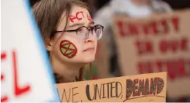  ?? PAT NABONG/SUN-TIMES ?? Ellen Trost-Rekich, 19, a student at Harper Community College in Palatine, holds a poster during the Global Climate Strike in downtown Chicago on April 19.