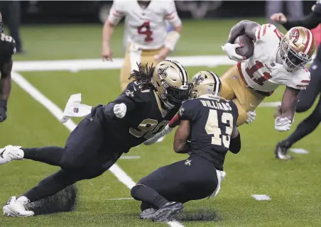  ?? Brett Duke / Associated Press ?? Wide receiver Brandon Aiyuk sees his progress stopped by New Orleans’ Malcolm Brown and Marcus Williams.