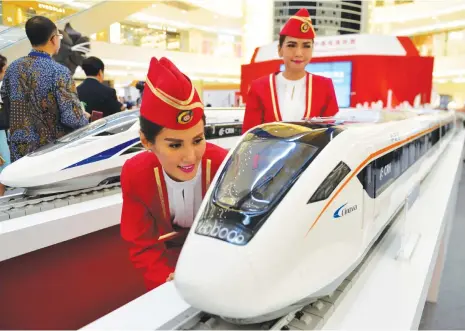  ?? (AFP) ?? This file photo shows Indonesian models looking at scale models of Chinese-made bullet trains, at a shopping mall in Jakarta on August 13, 2015