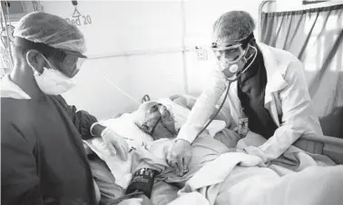  ?? HANI MOHAMMED/AP 2020 ?? Medical workers treat a COVID-19 patient in an intensive care unit at a hospital in Sanaa, Yemen.