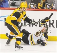  ?? Keith Srakocic / Associated Press ?? David Pastrnak of the Bruins, right, grabs the stick of the Penguins’ Sidney Crosby during the third period of Sunday’s game in Pittsburgh.