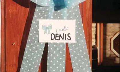  ??  ?? Denis is the first baby to be born to parents in Morterone for eight years. His parents placeda ribbon on the door of their home to announce his arrival. Photograph: Facebook / Comune di Morterone