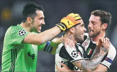  ?? ALBERTO LINGRIA / REUTERS ?? Juventus fullback Dani Alves (center) is congratula­ted by goalkeeper Gianluigi Buffon and Claudio Marchisio after scoring against Monaco during the UEFA Champions League semifinal second-leg at Juventus Stadium in Turin on Tuesday.