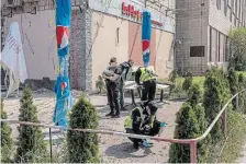  ?? ROMAN PILIPEY GETTY IMAGES ?? Police officers on Sunday work at the site where a building was damaged during a Russian drone attack in Kyiv, Ukraine. Over 40 drones were shot down over the capital.