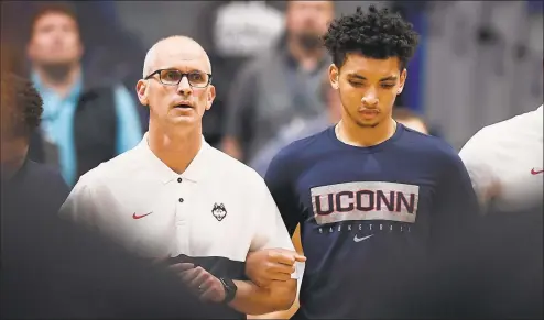  ?? Jessica Hill / Associated Press ?? UConn’s James Bouknight, right, locks arms with coach Dan Hurley during the national anthem before an October exhibition against Saint Michael’s in Hartford.