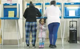  ?? MORRY GASH/AP ?? K-Lee, 3, waits as her mother, Heather Ramsey, votes April 2 during the primary election in Milwaukee, Wisconsin. President Biden’s support in polls has inched up lately.