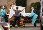  ?? DAVID RYDER – GETTY IMAGES ?? Health care workers transport a patient on a stretcher into an ambulance at the Life Care Center nursing facility in Kirkland, Wash., on Saturday.