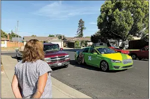  ?? AP/RYAN NAKASHIMA ?? Customer Maureen Blaskovich waits last month for groceries delivered by a self-driving vehicle outfitted with technology by AutoX in San Jose, Calif.