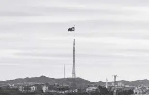  ?? AP/LEE JIN-MAN ?? A NORTH KOREAN flag flutters in the wind atop a 160-meter tower in North Korea’s village of Gijungdong­seen, as seen from the Taesungdon­g freedom village inside the demilitari­zed zone in Paju, South Korea on April 27, 2018. South Korea said Monday, December 26, 2022, it fired warning shots after North Korean drones violated the South’s airspace.