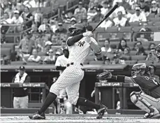  ?? Associated Press ?? ■ New York Yankees' Giancarlo Stanton hits a home run as Texas Rangers catcher Robinson Chirinos, right, looks on during the first inning of a baseball game Saturday at Yankee Stadium in New York.