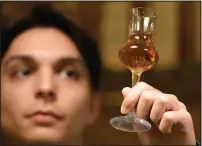  ?? ?? A bartender looks at a glass of plum brandy in Belgrade.