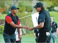 ?? USA TODAY SPORTS ?? Tiger Woods concedes a putt to Phil Mickelson during their headto-head match in Las Vegas on Friday. Mickelson prevailed to walk away with the $9 million winner’s check.