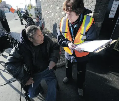  ?? JOHN LUCAS/EDMONTON JOURNAL ?? Volunteer Dorian Smith asks Gloria Bone, questions for this year’s Homeless Count outside the Bissell Centre on Thursday.