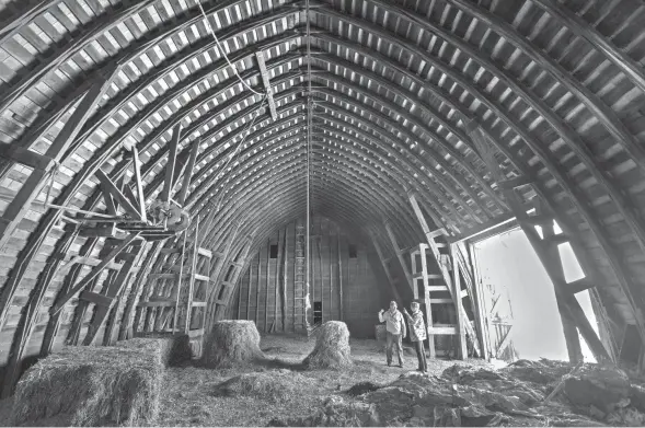  ?? PHOTOS BY MARK HOFFMAN/MILWAUKEE JOURNAL SENTINEL ?? Bruce Drinkman and his companion, Betty Jo Johnson, stand in the hayloft designed to hold about 10,000 bales of hay at the farm he bought in Ridgeland. Drinkman is getting back into dairy farming nearly a decade after losing his farm in Glenwood City.