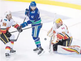  ?? DARRYL DYCK, THE CANADIAN PRESS ?? Flames goalie David Rittich makes a save off a tip from Canucks forward Jonah Gadjovich during pre-season action in Vancouver on Wednesday.