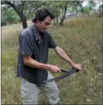  ?? AUDREY RODEMAN VIA AP ?? This photo shows writer Cain Burdeau sharpening a scythe he uses to cut the grass on a property in Contrada Petraro near Castelbuon­o,