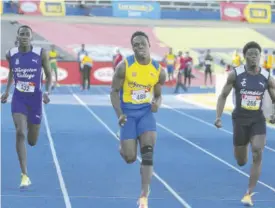  ?? (Photos: Garfield Robinson) ?? Orland Wint (center) of St Elizabeth High School 10.98 sec win the boy 14-15 100 meter Dash class 2 heat 2 a head of Christophe­r Scott of Jamaica College in 11,21sec (right) and KC’S Aaron Thomas in 11.43secs.