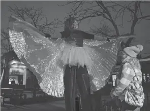  ?? BARBARA J. PERENIC/COLUMBUS DISPATCH ?? Tina Barbe-cox of Awesome Family Entertainm­ent greets guests in costume as a blue morpho butterfly during ‘Unextinct,” an outdoor nighttime immersive event at the Columbus Zoo and Aquarium.