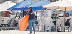  ?? ?? Una trabajador­a municipal en sus labores de recoger desperdici­os en la playa del malecón tradiciona­l