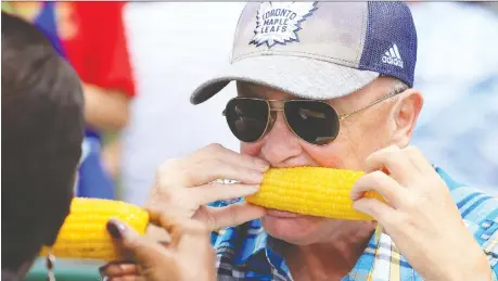  ?? NICK BRANCACCIO ?? Mark Barnes enjoys sweet corn during the Tecumseh Corn Festival at Lacasse Park in August. The municipali­ty says the 45-year-old festival has become too expensive and is looking for new ideas. The town will host a public informatio­n session on Feb. 12.