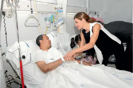  ?? PHOTO: REUTERS ?? Spain’s Queen Letizia greets a man injured after a van crashed into pedestrian­s at Las Ramblas.