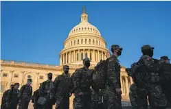  ?? STEFANI REYNOLDS GETTY IMAGES ?? Members of the National Guard gather outside the U.S. Capitol building on Tuesday. Thousands of guard members are set to arrive before Jan. 20.
