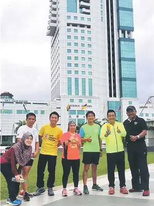  ??  ?? JOM SAHUT CABARAN: Zamri (dua kanan) bersama ahli-ahli Undergroun­d Runners Sibu di hadapan Wisma Sanyan yang akan menjadi lokasi Sibu Tower Run 2018.