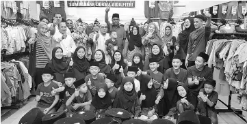  ??  ?? The orphans with staff of Kainmewah Rumah Amal Kasih.