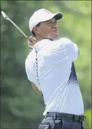  ?? Sam Greenwood / Getty Images ?? Tiger Woods hits off the fourth tee during the third round of the Quicken Loans National on Saturday. He birdied the hole.