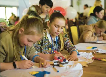  ?? HANNA ARHIROVA/AP ?? Olha Hinkina, center, attends an art session May 3 at a recovery camp for children near Lviv, Ukraine.