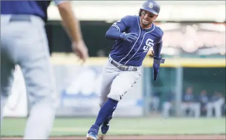  ?? PHOTO/JOHN MINCHILLO ?? San Diego Padres’ Greg Garcia runs home to score on an RBI-single by Manny Machado off Cincinnati Reds starting pitcher Trevor Bauer in the first inning of a baseball game on Monday, in Cincinnati. AP