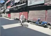  ?? AP ?? A man rides through a closed market during a shutdown in Srinagar on Monday.