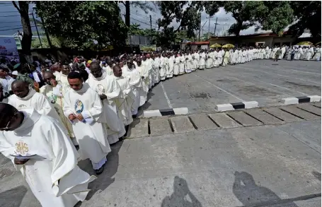  ??  ?? Photo ci-dessus : Le 22 mai 2018, les églises catholique­s du Nigéria ont organisé des procession­s(ici à l’église de Saint-Léo, à Lagos), en solidarité avec les victimes des violences qui secouent le pays, et en particulie­r de l’attaque survenue le 24 avril dans une église de l’État de Benue, qui a fait 18 morts, dont deux prêtres. Depuis novembre 2017, le centre du Nigéria est en proie à de nouveaux affronteme­nts communauta­ires. Bien que les parties soient de confession­s différente­s, ce sont les enjeux agraires qui expliquent le conflit, relancé par l’interdicti­on de la transhuman­ce, dont la mise en oeuvre semble avoir été mal anticipée par les autorités. (© Pius Utomi Ekpei/AFP)