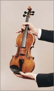  ?? ANDREW WHITE — THE NEW YORK TIMES ?? Jason Price, director of Tarisio auction company, holds the - da Vinci” Stradivari­us violin in Berlin, Germany, on April 30. Crafted in 1714 and played in “The Wizard of Oz” and other classic films, Toscha Seidel's Stradivari­us could sell for almost $20million at an online auction.