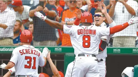  ?? AP-Yonhap ?? Washington Nationals Brian Goodwin, center, celebrates his two-run home run with Jose Lobaton, right, during the third inning of a baseball game against the Milwaukee Brewers in Washington, Thursday. Teammate Max Scherzer who scored on the play was...