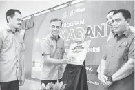  ?? — Gambar Bernama ?? PERASMIAN: Fahmi menurunkan tandatanga­n pada plak perasmian Program Kita Madani di Pulau Tuba, Langkawi, semalam.