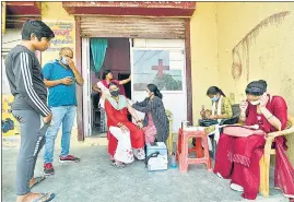  ?? SUNIL GHOSH /HT PHOTO ?? A health worker administer­s a Covid-19 vaccine in Noida on Monday.