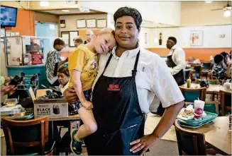  ?? STEVE SCHAEFER / SPECIAL TO THE AJC PHOTOS ?? Employee Jada Pass says goodbye to Caden Brady Doyle, 5, right before the doors of the S&amp;S Cafeteria closed for good Sunday in Atlanta. Caden has been eating at the cafeteria since he was 2 years old and knows many of the employees.