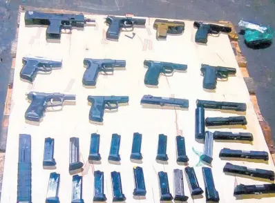  ?? CONTRIBUTE­D ?? A cache of illegal guns seized at the port recently