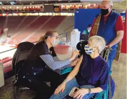  ?? ADOLPHE PIERRE-LOUIS/JOURNAL ?? Registered nurse Sophia Tracey-Gay gives the COVID-19 vaccine to Karen Beaton of Rio Rancho, as her husband, Thomas Ponder, watches. An estimated 1,700 vaccines were administer­ed at the Pit on Wednesday.