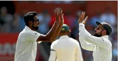  ?? GETTY IMAGES ?? Ravi Ashwin, left, and Virat Kohli celebrate the wicket of Australian batsman Usman Khawaja.