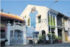  ??  ?? The “Wu Shu Girl” mural painting by Ernest Zacharevic decorates a building facade on Muntri Street, a popular tourist area.