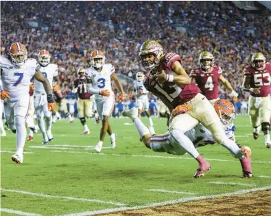  ?? JAMES GILBERT/GETTY ?? Florida State quarterbac­k Jordan Travis dashes down the sideline for some of his 353 total yards in a win over Florida on Friday night.