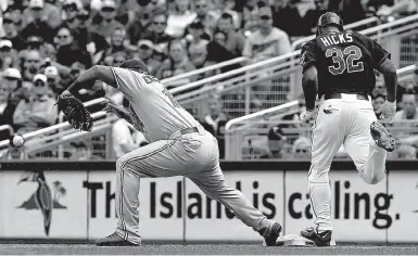  ??  ?? Minnesota Twins’ Aaron Hicks makes it safely to first as Toronto Blue Jays first baseman Edwin Encarnacio­n bobbles the ball on a throwing error by Blue Jays shortstop Jose Reyes on Sunday in Minneapoli­s.