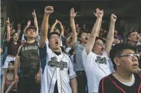  ?? ISAAC LAWRENCE/NEW YORK TIMES ?? Fans of the Lamigo Monkeys cheer during a May 13 game at the Taoyuan Internatio­nal Baseball Stadium in Taoyuan City, Taiwan.